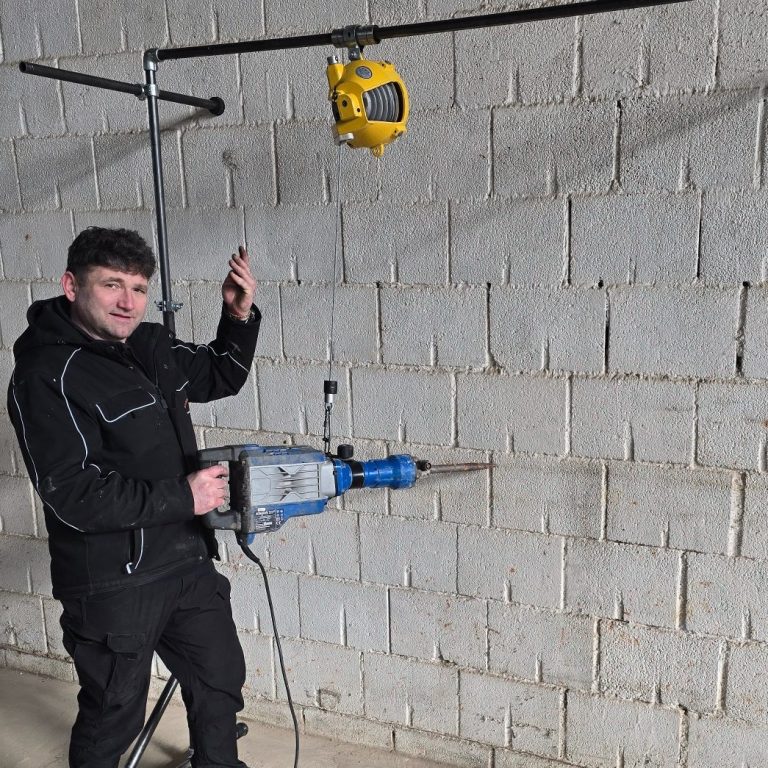 Arbeiter nutzt eine Mauersäge mit BalanToolce Balancer-System zur ergonomischen Unterstützung schwerer Handgeräte auf der Baustelle